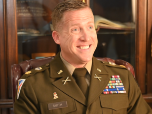 New Valley Forge Military College Commandant of Cadets Jared D. Smith smiles and sits in a chair as he is being interviewed during an introduction conversation.