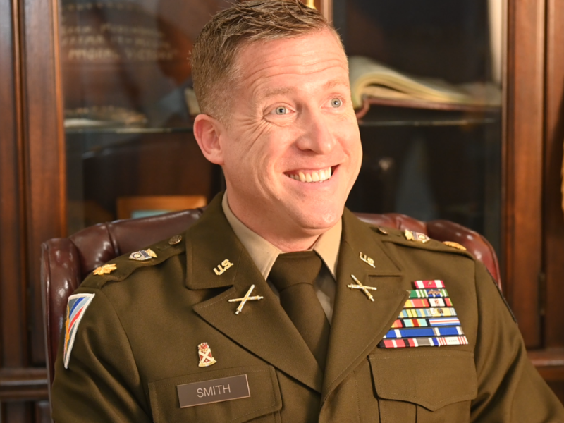 New Valley Forge Military College Commandant of Cadets Jared D. Smith smiles and sits in a chair as he is being interviewed during an introduction conversation.